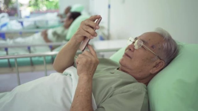 在医院的疗养院中使用移动智能手机设备的快乐的老年亚洲患者或养老金领取者的肖像。高级生活方式活动娱乐。
