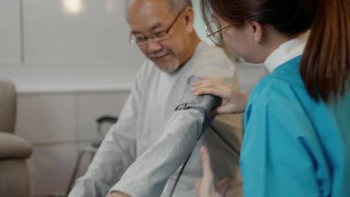 亚洲护理医生检查老年患者使用血压计。护士探访并照顾病人，老人在客厅检查老年老人，保健保险理念。