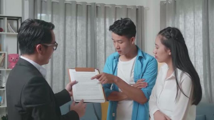 亚洲夫妇听房地产经纪人解释房屋买卖合同