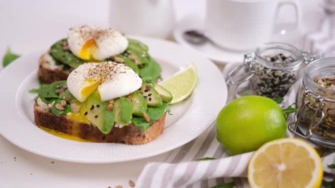 健康的早餐或小吃-在盘子上煮荷包蛋，软奶酪和鳄梨三明治