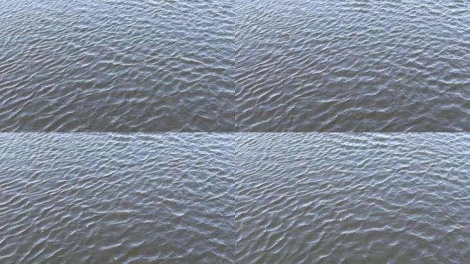 流着浅灰色平静的河水。水和波浪背景。4k视频。