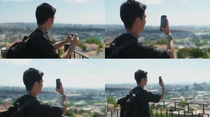 年轻男性游客在历史老城用手机拍照和录像