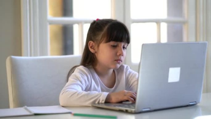 一个视力障碍的小女孩正在看电脑屏幕做作业