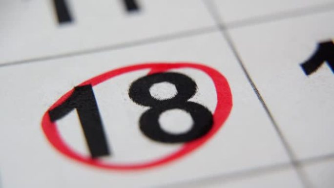 一个月的第18天是圆圈。红色标记从纸质日历中圈出一个月的第十八天。日历上非常重要的日期。