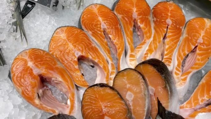 鱼市的冰镇柜台上放着一片片新鲜的生鲑鱼排。