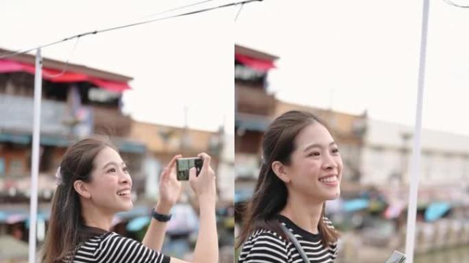 年轻的女性影响者拿着相机分享了录制的视频。泰国安帕瓦的旅行剪辑和视频记录器