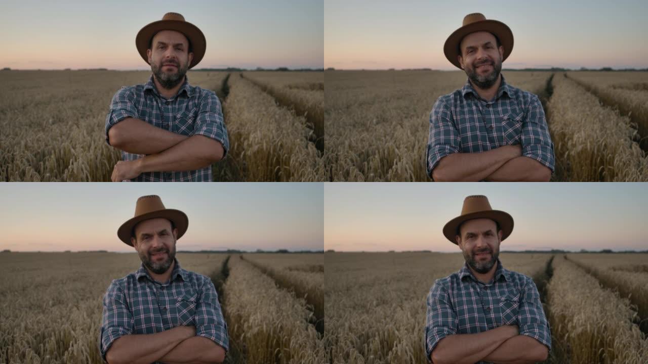肖像农民留着帽子的男人站在麦田里。农场工人。日落的天空。肖像高加索农民男子穿着帽子的格子衬衫看着相机