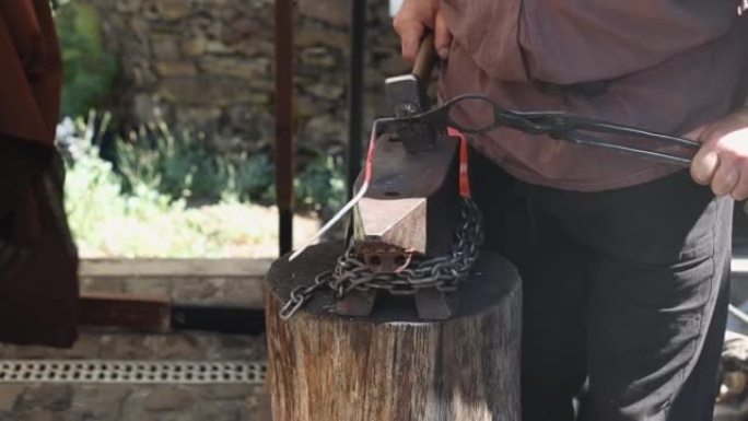 中世纪的铁匠用大锤锻造炽热的铁。