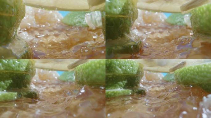 相机在蜂蜜上平移，在绿色柠檬片之间，蜂蜜从它们身上滴下来。超级宏观幻灯片