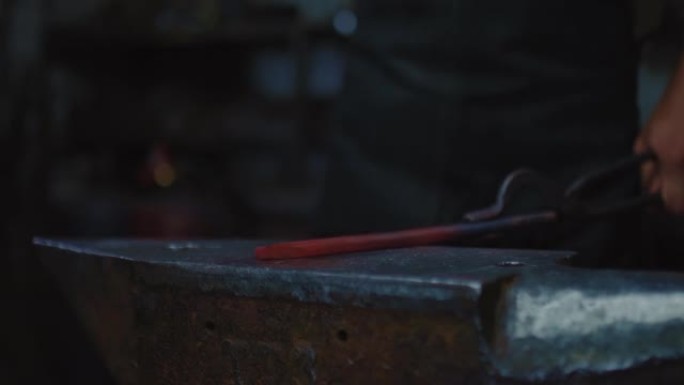 专业铁匠用铁锤和铁砧在锻造中塑造未来的刀，特写视图，4K，Prores
