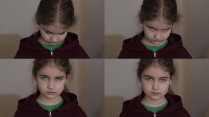 肖像悲伤的小女孩看着相机。思考好奇心的孩子在室内看着相机特写。沮丧的脸眼睛严肃沉思的孩子。严重的学生