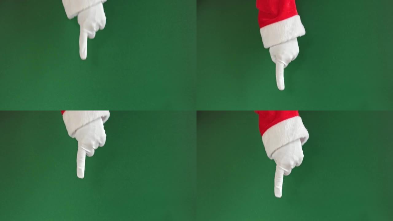 圣诞老人的手指着绿色背景上孤立的食指。特写。戴着白色手套的手用一根手指向下指。色度键屏幕。广告手势。