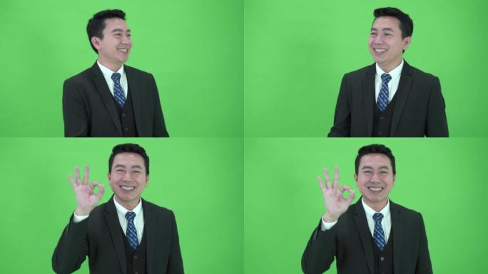 亚洲商人在色度绿色屏幕背景上显示一个好的手势。