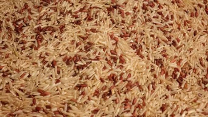 干红色和长糙米壁纸。特写。谷物掉落倒了一堆。世界危机，出口，进口。收获问题，制裁。价格上涨和粮食供应