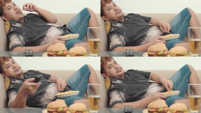 大个子男人在吃快餐后睡在沙发上不健康的汉堡与啤酒，不健康的生活方式概念。