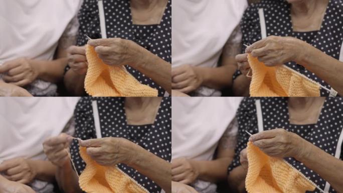 老年妇女和女儿一起编织以保护痴呆症和记忆力减退。