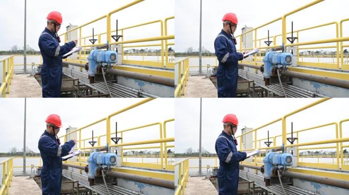 水厂维修技术人员，机械工程师检查水处理厂的控制系统。