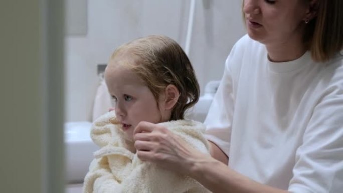 Young mother wipes her daughter after a shower