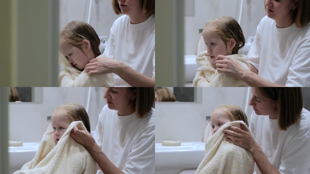 Young mother wipes her daughter after a shower