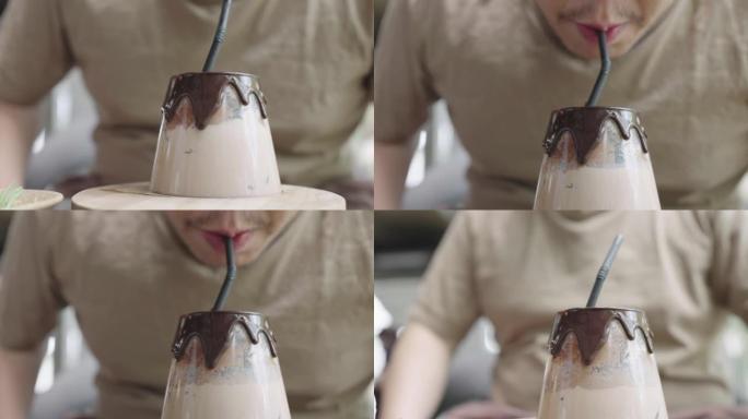 大个子男人喝高档玻璃杯里的牛奶。