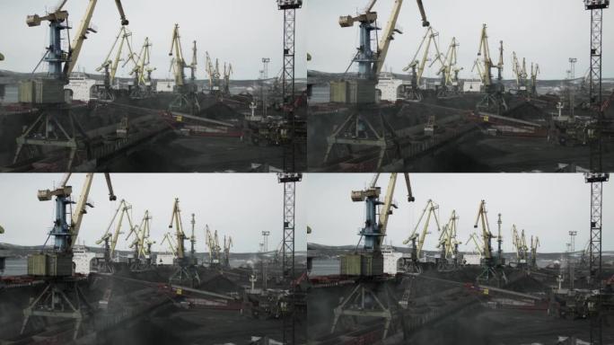 在大型起重机和传送带的帮助下，将煤炭运输的海船装载在海港。货车从野外带来了原材料