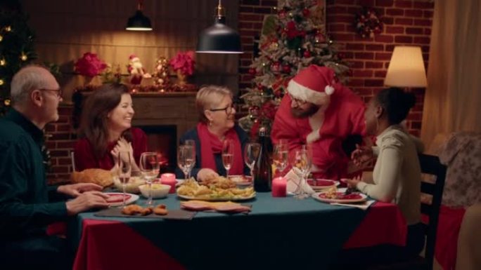 男子伪装成圣诞老人在家里的圣诞晚宴上与幸福的女人交谈