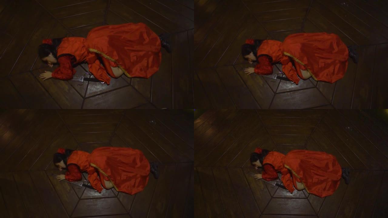 一名中国妇女穿着红色的中国连衣裙睡在剑旁的木地板上