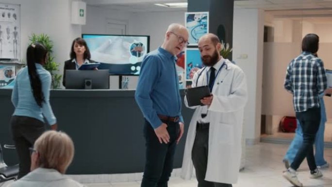 医生和高级患者在医院接待处看数字平板电脑