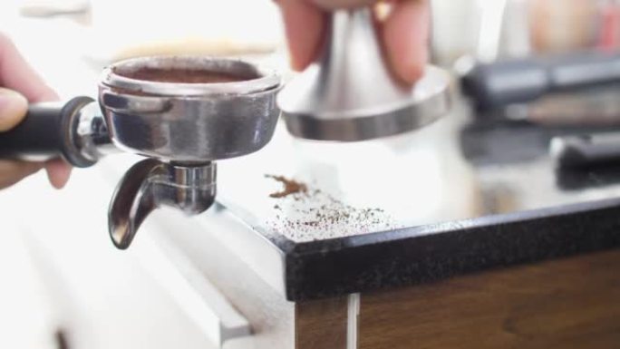 咖啡师用篡改将研磨咖啡压入Portafilter的特写镜头