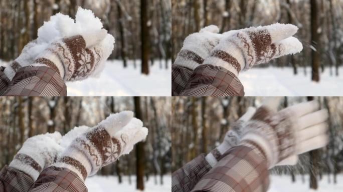一个美丽的年轻面目全非的女人从她的手掌吹雪。女孩站在冬日森林间，在晴天玩雪。女人的手放在手套里。慢动