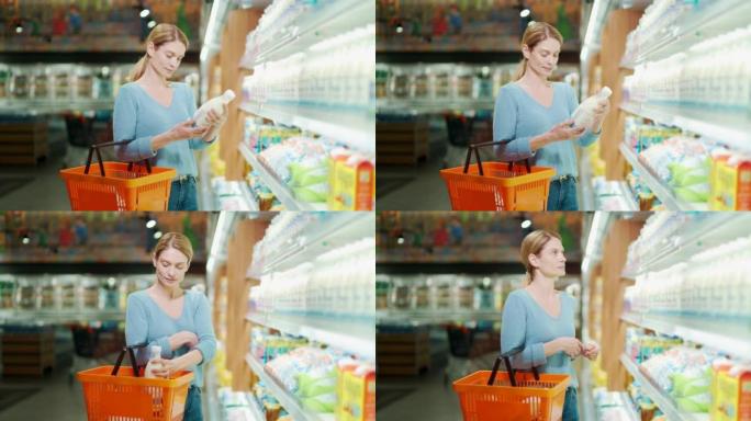 一名妇女选择乳制品，手里拿着一瓶牛奶。一位女士站在杂货店里拿着购物篮挑东西。研究并阅读标签上的信息。
