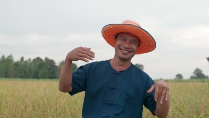 戴着帽子的亚洲年轻农民看着相机跳舞
