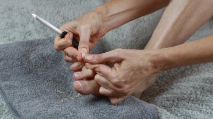 脚指甲护理。一个女人用指甲锉擦指甲。
