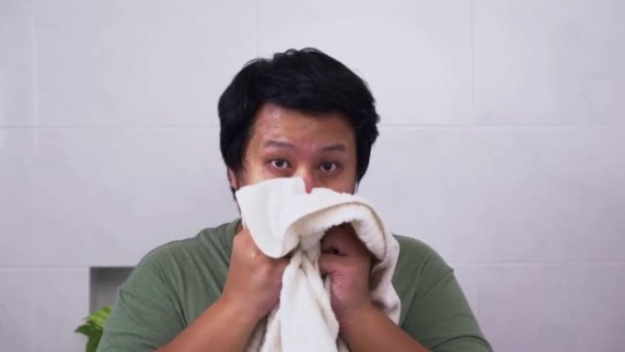 一名男子洗完后用毛巾擦干脸