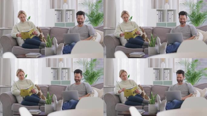 已婚现代中年夫妇一起坐在家里的客厅沙发上享受平静放松的生活方式。快乐，微笑的妻子看书，而丈夫则在笔记