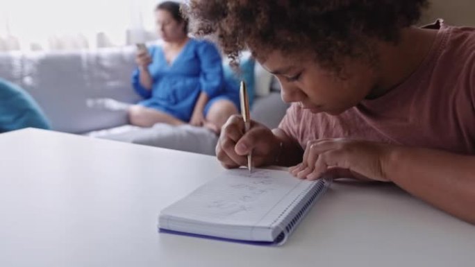 动手。黑人女孩在家在笔记本上画画。