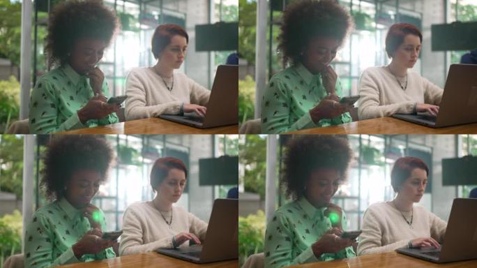 People using cellphone and laptop at coffee shop. 