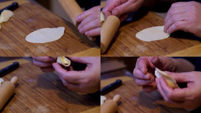 准备饺子。遵循传统食谱。推出面团做饺子。涂抹馅料并形成饺子。一位老年妇女皱着皱纹的手的特写。4k
