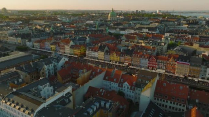 在黄金时段飞越市中心的历史建筑。Nyhavn前码头的彩色联排别墅外墙。丹麦哥本哈根