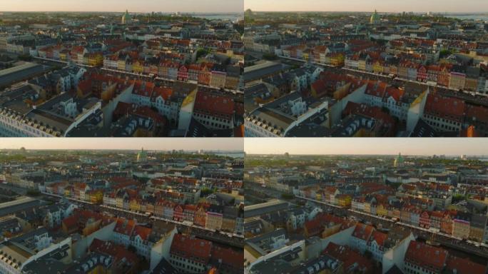 在黄金时段飞越市中心的历史建筑。Nyhavn前码头的彩色联排别墅外墙。丹麦哥本哈根