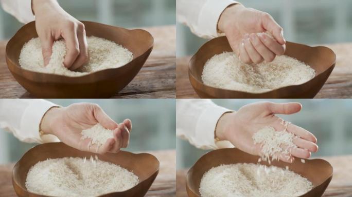 女性手感干净的生米和米饭滑落到木碗中