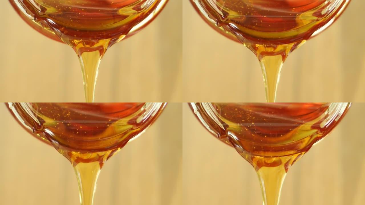 从玻璃罐中倒出蜂蜜的特写镜头。健康美容产品可持续生活理念。