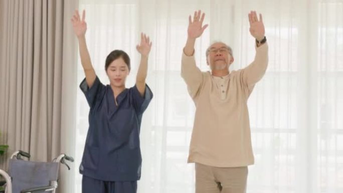 身穿蓝色服装的专业护士帮助老年残疾亚洲男子锻炼和在家与治疗医生一起旋转