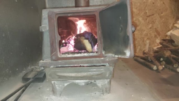 在铸铁火炉中燃烧的柴火为房屋供暖