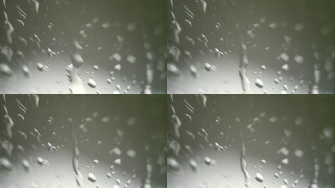 湿窗玻璃。雨滴。外面的绿树