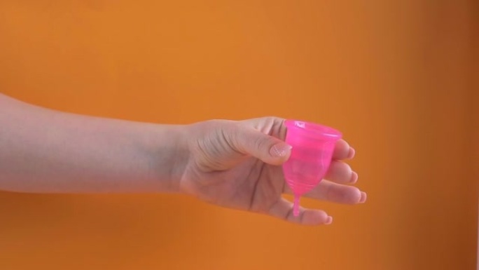 女性手中的乳胶月经杯，女性在月经期的替代卫生用品。