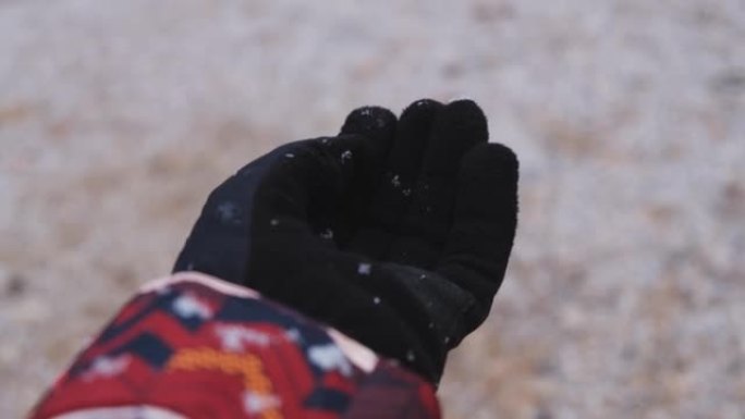 雪手手套掉落。女人的手的特写。