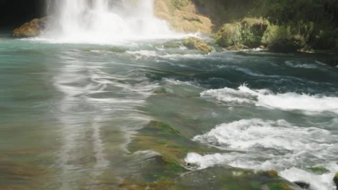 水很快流到岩石上。山河。瀑布撞到岩石上。绿松石色。