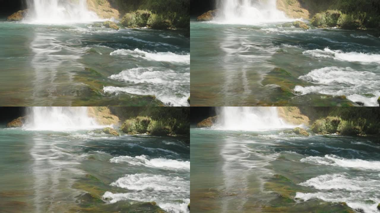 水很快流到岩石上。山河。瀑布撞到岩石上。绿松石色。