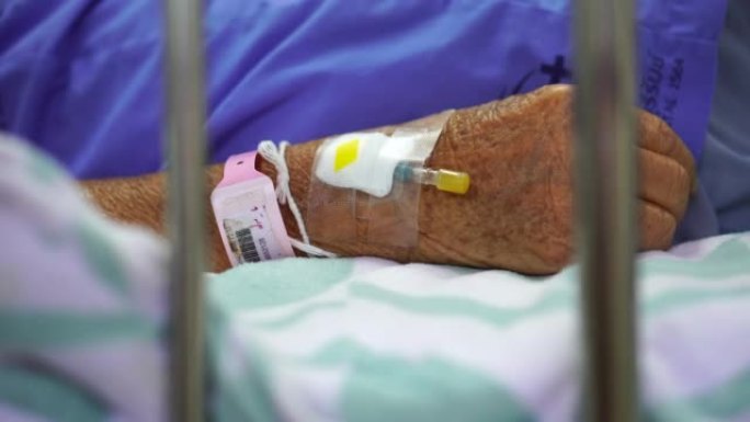 一名老年妇女在医院的病床上生病。
